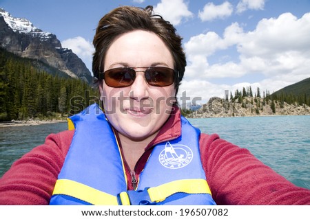 A woman wearing a life jacket on the water.