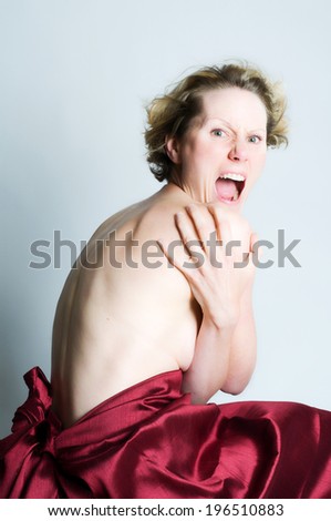 A woman with no shirt on and covering herself.