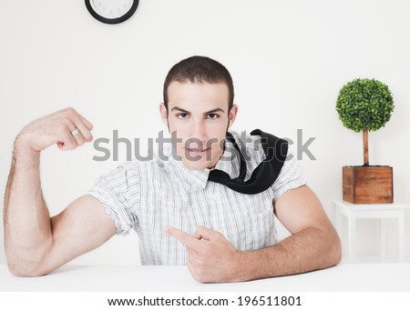 A guy flexing his muscles and a small tree in the background.