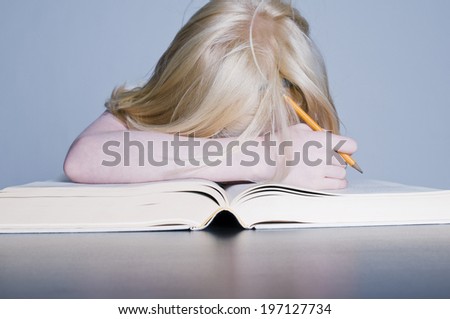 A child has fallen asleep doing their school work.