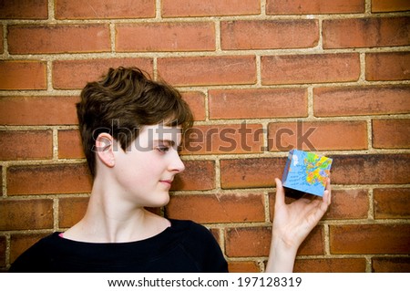 A person glances at a map of the world in cube form.