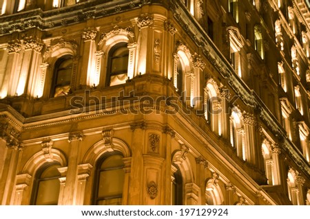 Flood lights illuminate the windows of a large building.