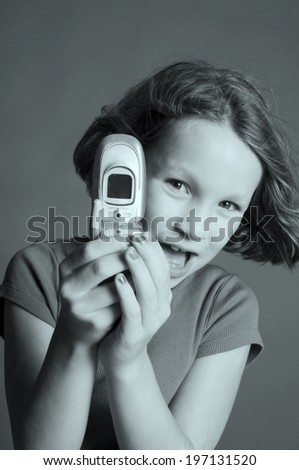 A child with a flip phone open in her hands.