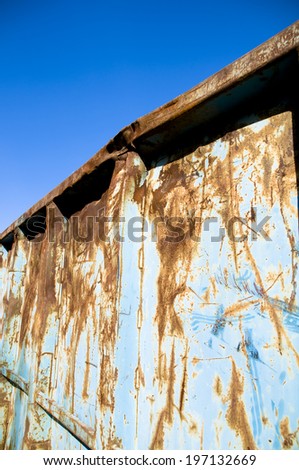 A metal container that is rusted and blue.