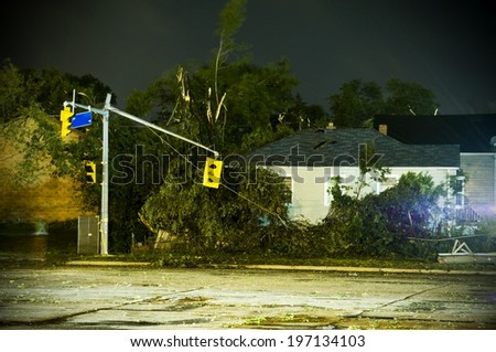 A wind damaged home with a dirty road and broken lights.