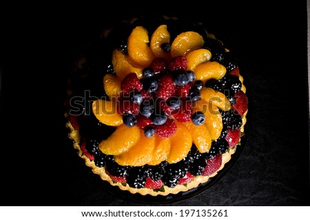 A pie shell filled with various types of fruit.