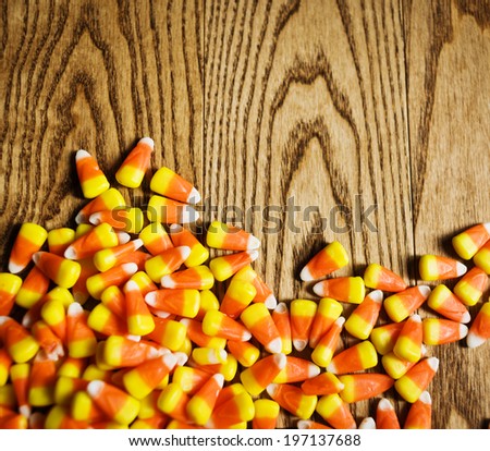 Candy corn that has been spilled on wood.