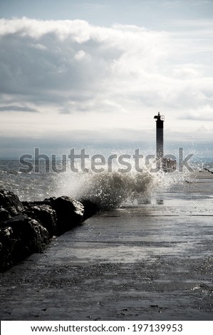 Waves crashing into the wall of a lighthouse jetty.