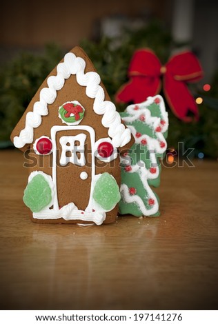 Gingerbread house and gingerbread Christmas tree on a table.