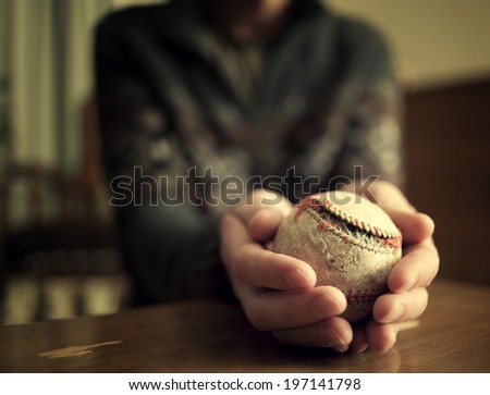 A baseball ripping apart held by a man.