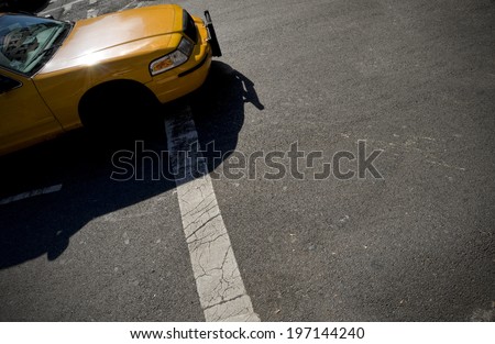 A yellow sedan without the front wheel on the road.