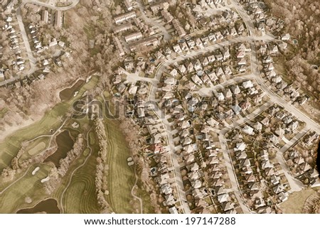 A large town lined with row upon row of houses is captured from above.
