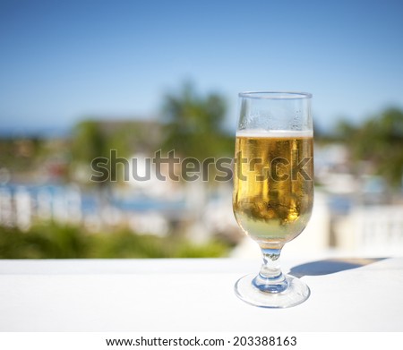 Glass of beer on a ledge at tropical hotel