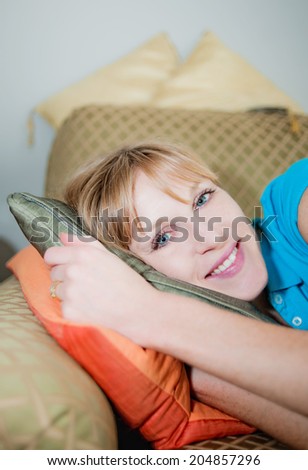 Woman lying on side on couch smiling