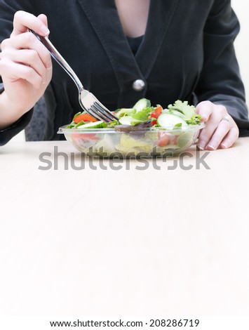 Woman eating salad at work