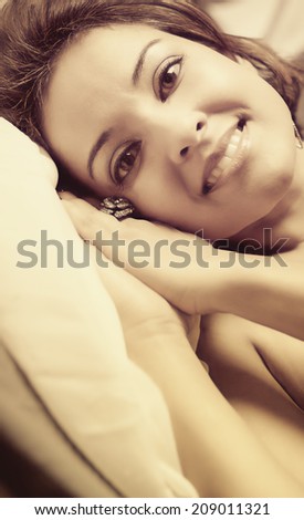 Young woman in bed wearing make-up