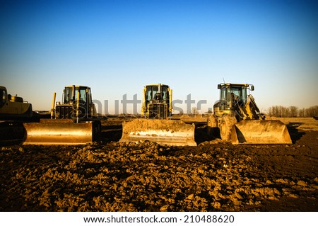 Two bulldozers and a front loader