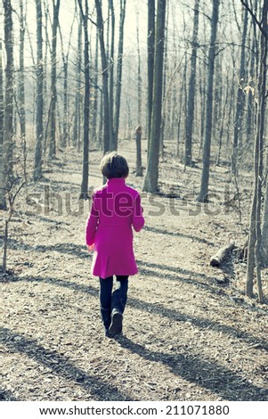 Girl walking in the woods in Winter