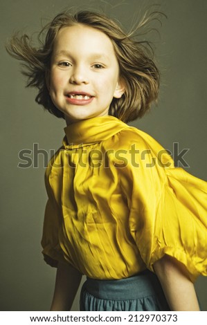 Gap-toothed girl in yellow blouse