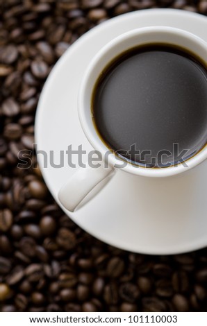 cup black coffee on a lot of coffee beans