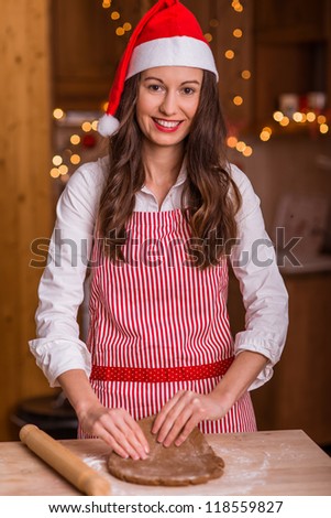 Christmas baking santa woman smiling happy having fun with Christmas preparations wearing Santa hat