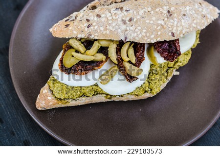 Gourmet sandwich with pesto sauce and olives