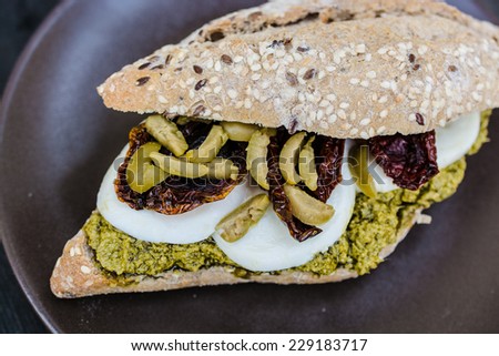 Gourmet sandwich with pesto sauce and olives