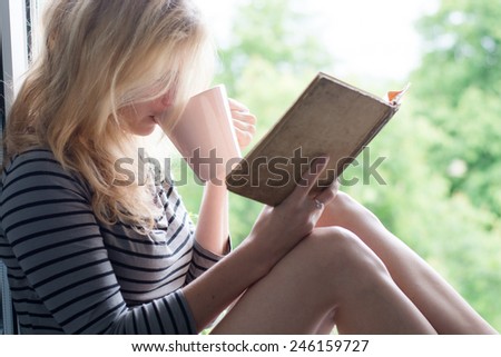 Woman lying in a garden and enjoying book reading