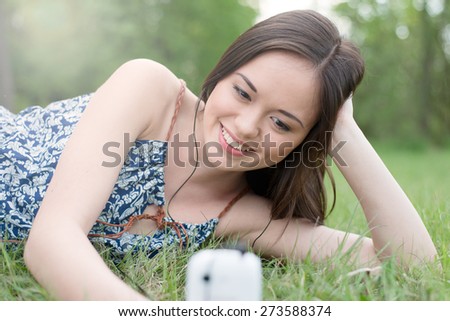 Beautiful asian smiling woman talking on cell phone outdoor