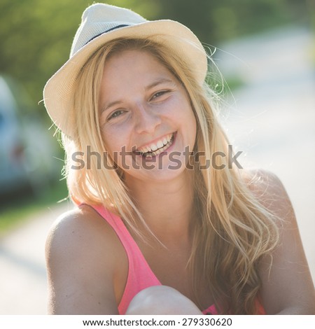 Summer girl portrait. Blonde woman smiling happy on sunny summer or spring day outside in park