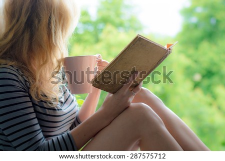 Blonde woman reading book in the garden