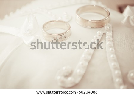 stock photo golden wedding rings on small white cushion