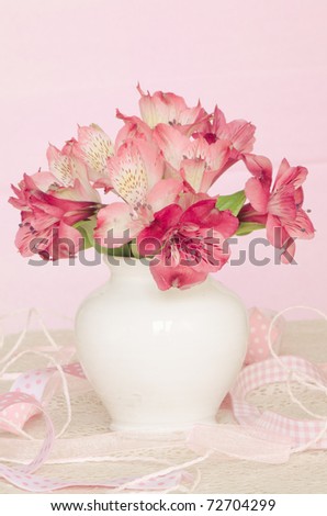 Bouquet of pink flowers in vase isolated on pink background