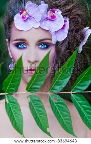 Portrait of very beautiful woman with orchid in her hair