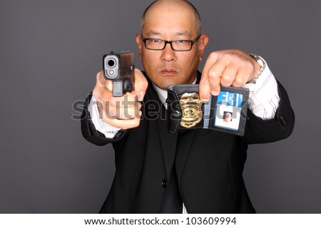 FBI Agent with gun and holding a badge.