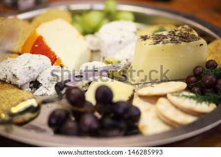 Assorted cheeses and snacks on a tray.