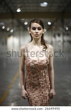 A woman wearing a pretty dress in a warehouse.