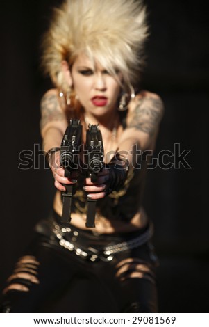 Young alternative woman with dual automatic pistols.