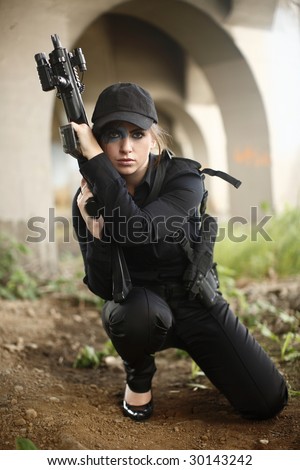 A sexy woman with an automatic rifle.