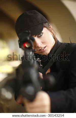A sexy woman pointing an automatic rifle.