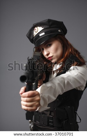 A young and sexy officer pointing an assault rifle.