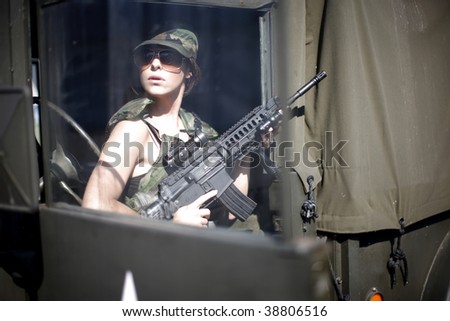 A young female soldier with an assault rifle.