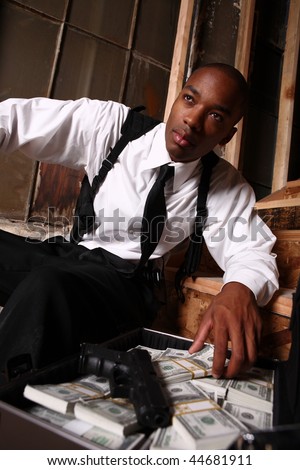 Young stylish man with a briefcase of cash and a gun.
