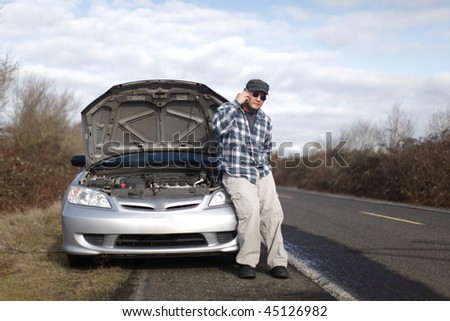 Man on cellphone with car trouble.