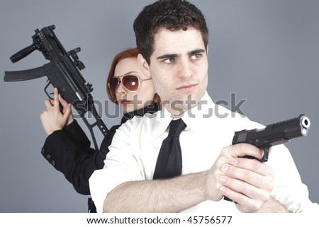 An attractive young couple with guns.