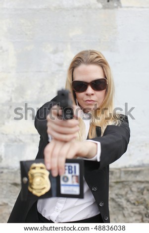 A sexy FBI agent aiming a pistol.