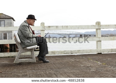 Man using laptop on the pier.