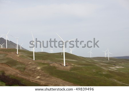 A hill with wind mills to harness the wind for energy.