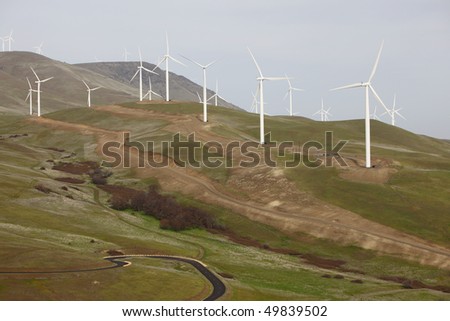 A hill with wind mills to harness the wind for energy.