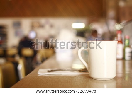 A cup of coffee on the counter at a diner.